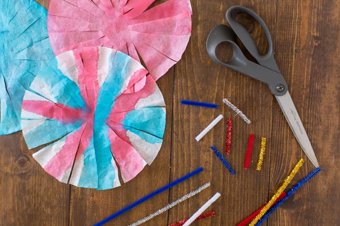 painted coffee filters and pipe cleaners on a table