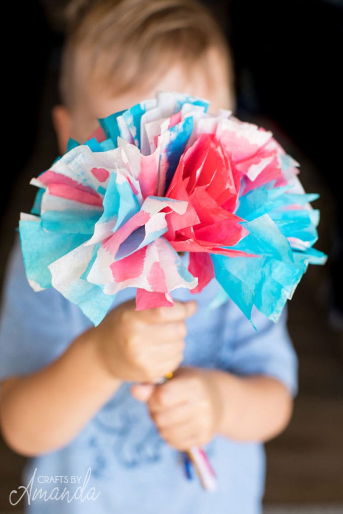 little boy holding a boquet of flowers made from watercolors and coffee filters