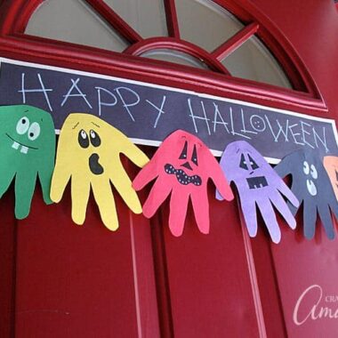 Make this adorable Halloween Handprint Ghoul Banner with the kids to hang on the door! A great way to greet trick or treaters. Would be a fun troop or classroom project too!