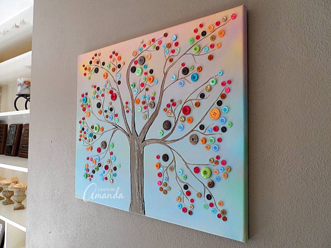 Make this beautiful button tree for your home. This button tree tutorial shows you step by step how to turn an ordinary canvas into colorful wall art! - by Amanda Formaro of Crafts by Amanda