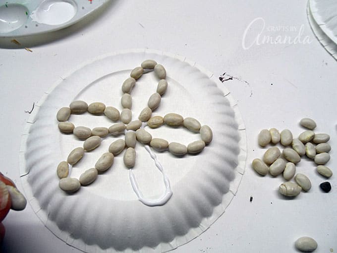 gluing on beans to paper plate