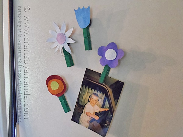 Aww what a cute way to display photos or kid's artwork on the fridge!  Flower magnets made from old denim. Genius.