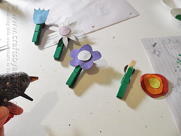 Glue the denim flowers to the clothespins