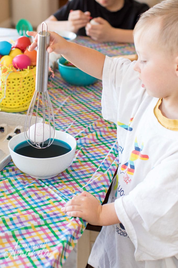 little boy dyeing easter eggs