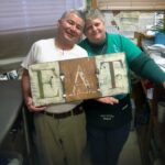 Manny and April of Manny's Snack Shack in Twin Lakes, WI with EAT Sign by Amanda Formaro @amandaformaro of Crafts by Amanda