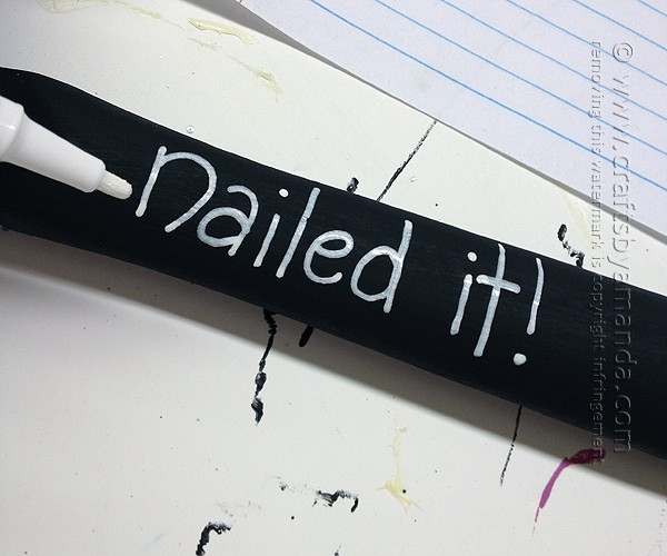Paint the hammer's wooden handle black and use a white paint pen to write nailed it