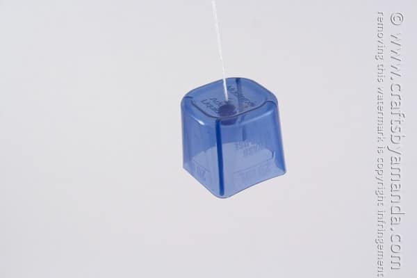 plastic lid dangling from a string