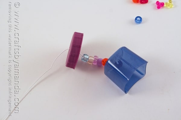 plastic milk lid added to a string with beads