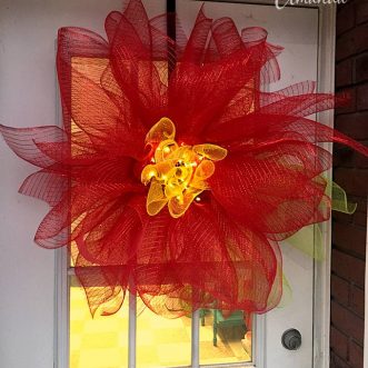 Learn how to make this beautiful deco mesh poinsettia flower - perfect for Christmas! All you need is a styrofoam disc, deco mesh and floral pins. Get the full tutorial for this pretty deco mesh flower!