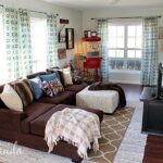 Decorate your family room with movie theater themed decor for a fun mini theater room experience! Fun movie room wall art, zombie pillows, a real popcorn maker and even candy and snacks make this room a fun place for family movie night.