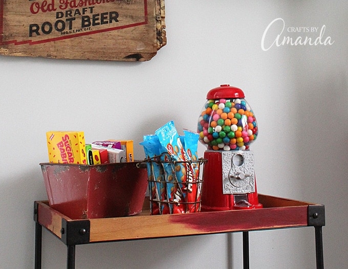 Decorate your family room with movie theater themed decor for a fun mini theater room experience! Fun movie room wall art, zombie pillows, a real popcorn maker and even candy and snacks make this room a fun place for family movie night.