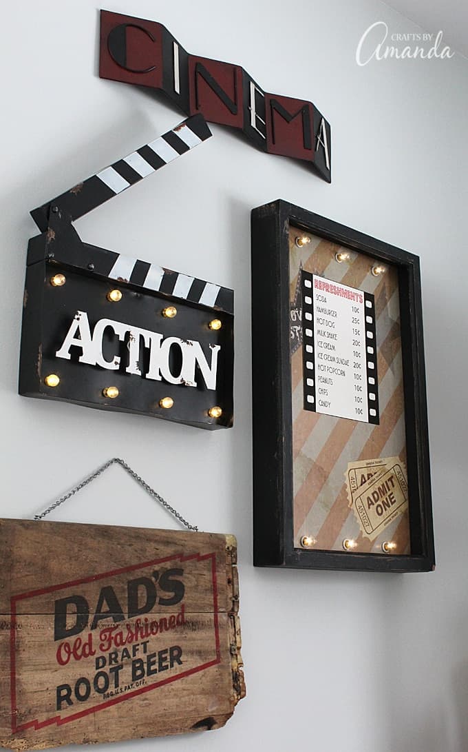 Decorate your family room with movie theater themed decor for a fun mini theater room experience! Fun movie room wall art, zombie pillows, a real popcorn maker and even candy and snacks make this room a fun place for family movie night.