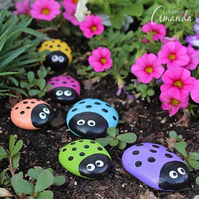 Ladybug painted rocks in a flower bed