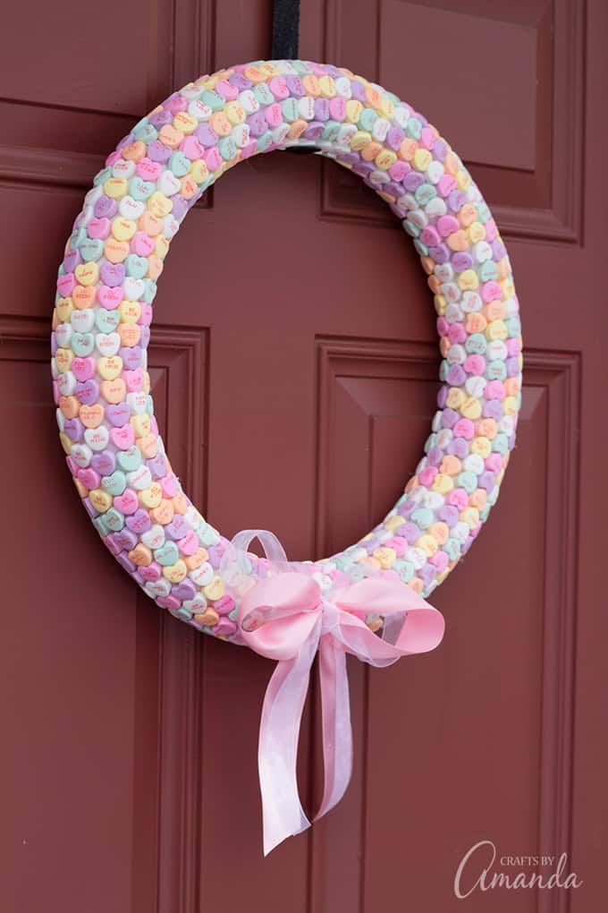 Conversation hearts turned into a wreath hanging on door