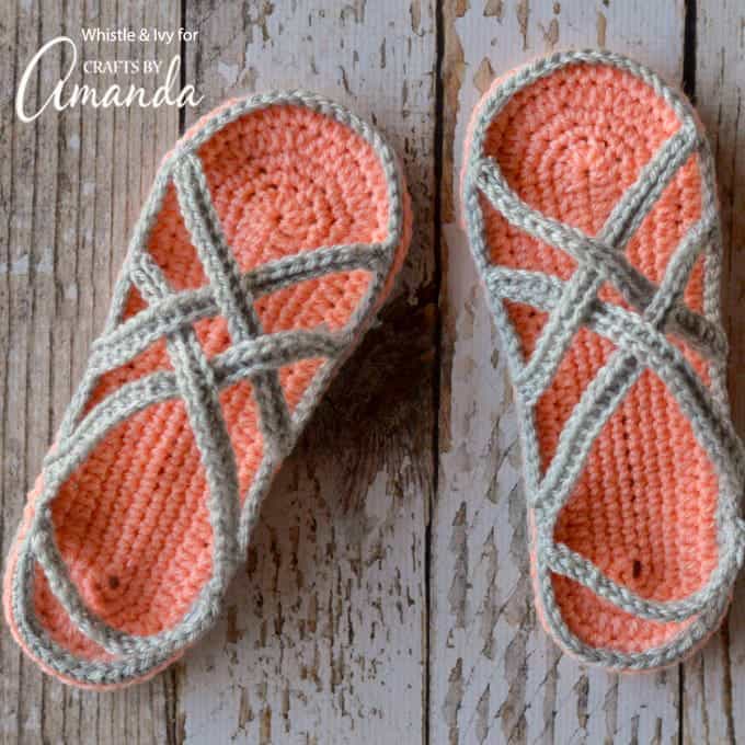 coral and grey colored crochet sandals on wood background