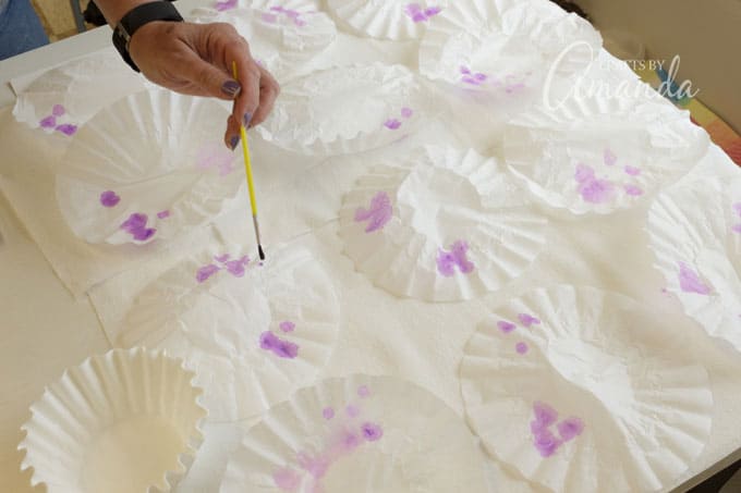 Place coffee filters onto the paper towels and paint with watercolors.