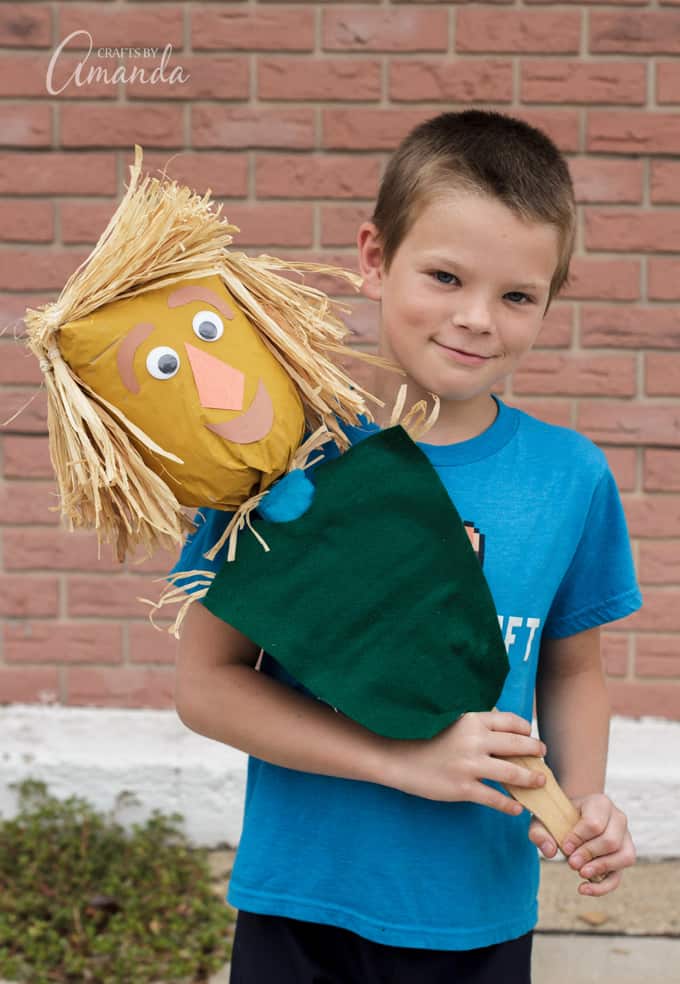 Kid holding paper bag scarecrow
