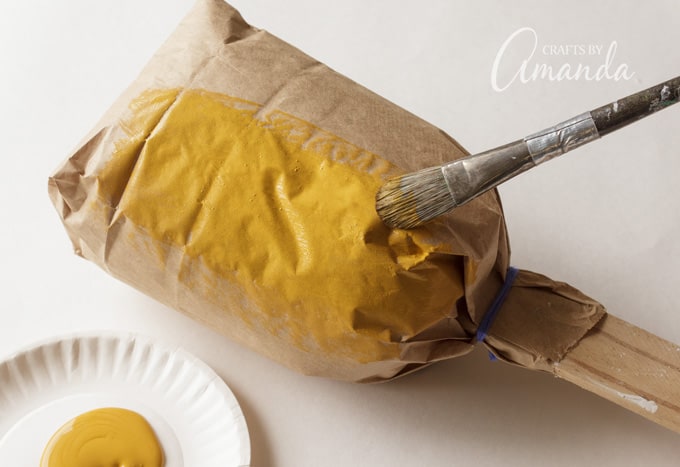 Paint the bag with goldenrod paint and set aside to dry.