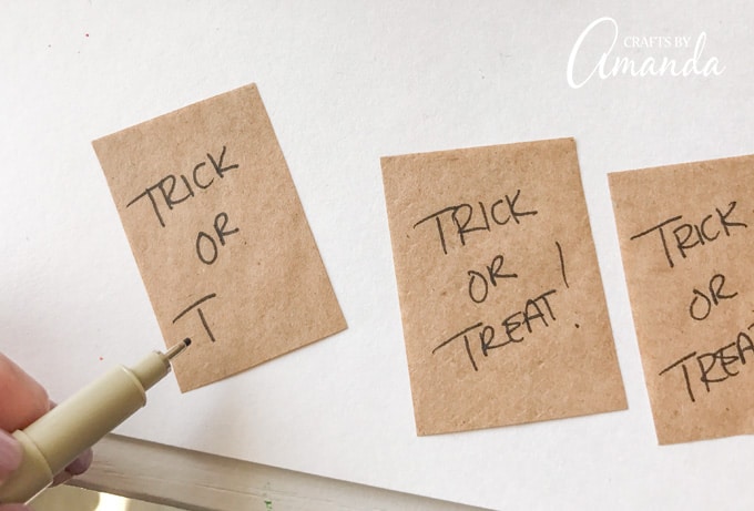 Write “TRICK OR TREAT!” on the paper bag rectangle. 