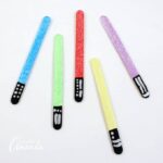 Keep your place in your favorite books by making glittery lightsabers in different colors! These lightsaber bookmarks are great for home or school.
