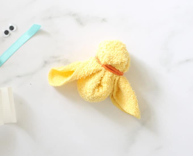 yellow washcloth twisted into shape of a chick