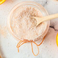 overhead photo of DIY orange scented bath salts in a glass container