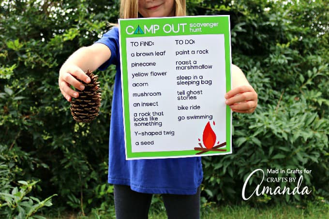 girl holding pine cone and scavenger hunt sheet