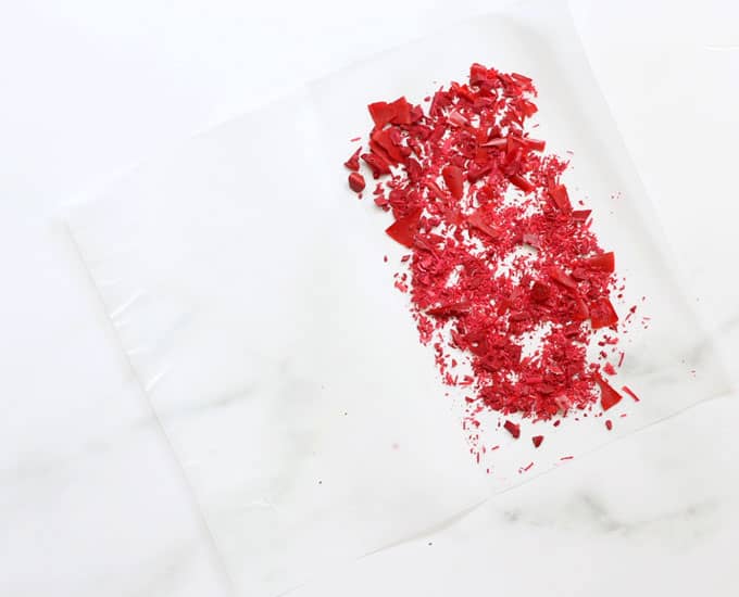 Chopped red crayons on parchment paper
