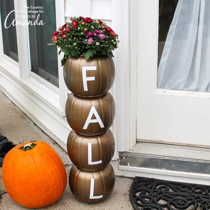 Easily make this stacked pumpkin planter using plastic pumpkins from the dollar store and some vinyl adhesive letters for a fun fall statement piece!