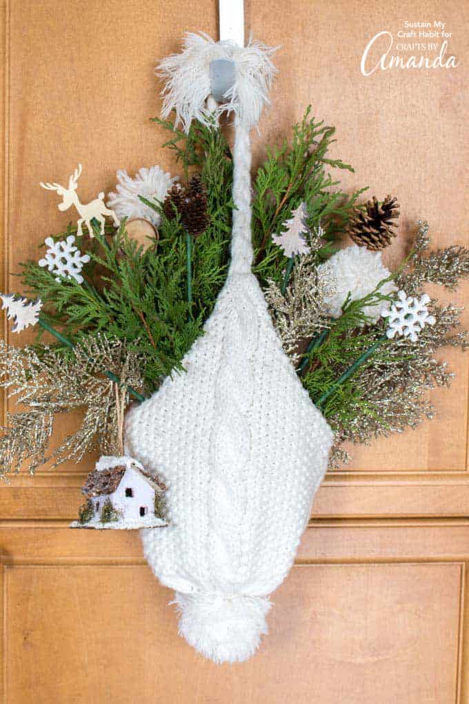 door hanging made out of a winter hat and greenery