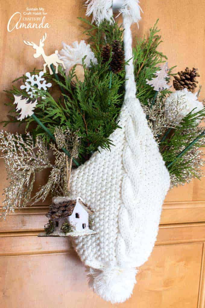 winter hat door hanging made from a knitted hat and winter greenery