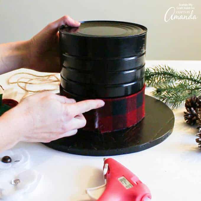 Gluing on cut ribbon to the base of snowman hat centerpiece