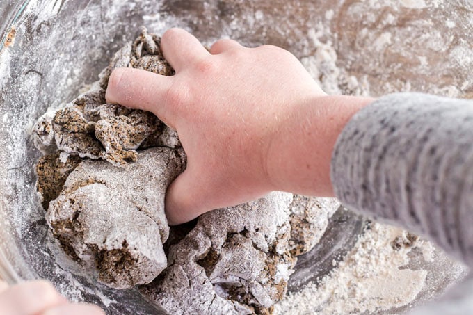 child's hand kneading dough