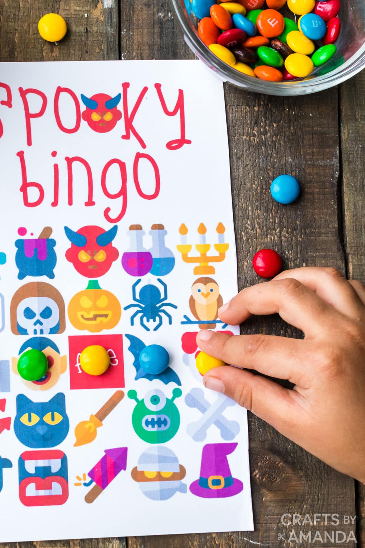 childs hand putting candy on bingo card