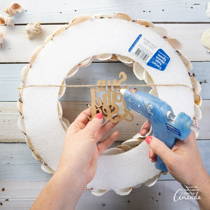 attaching wooden cut out sign to the back of the wreath