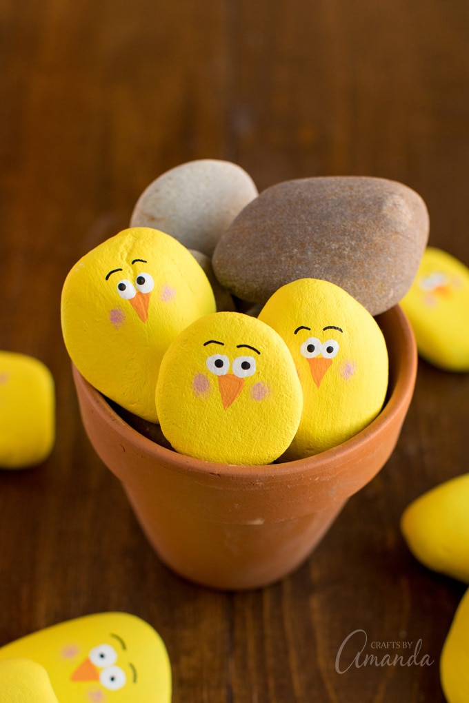 terra cotta pot filled with yellow painted rock chicks