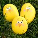 3 yellow painted rocks chicks in grass