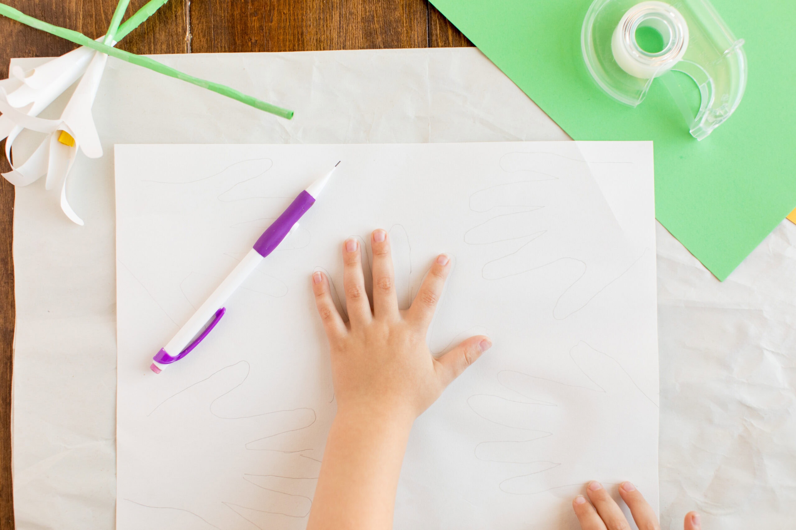 kids hand on construction paper