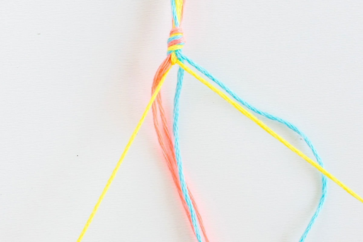 pulling embroidery floss to the top of knot