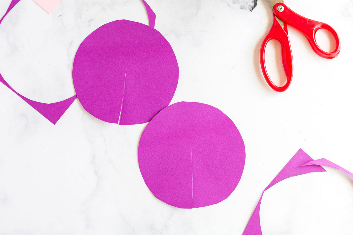 two paper circles sitting on white surface with scissors
