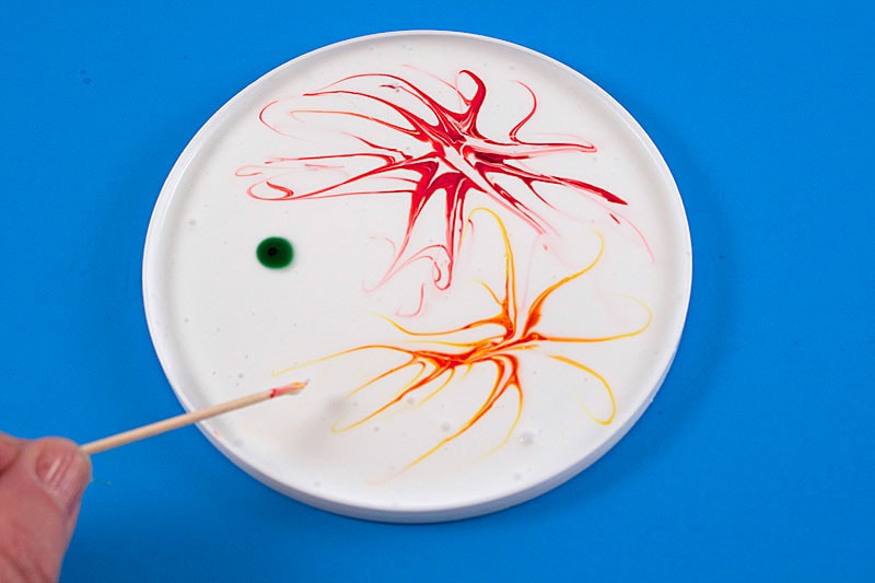 dragging food coloring through glue with toothpick