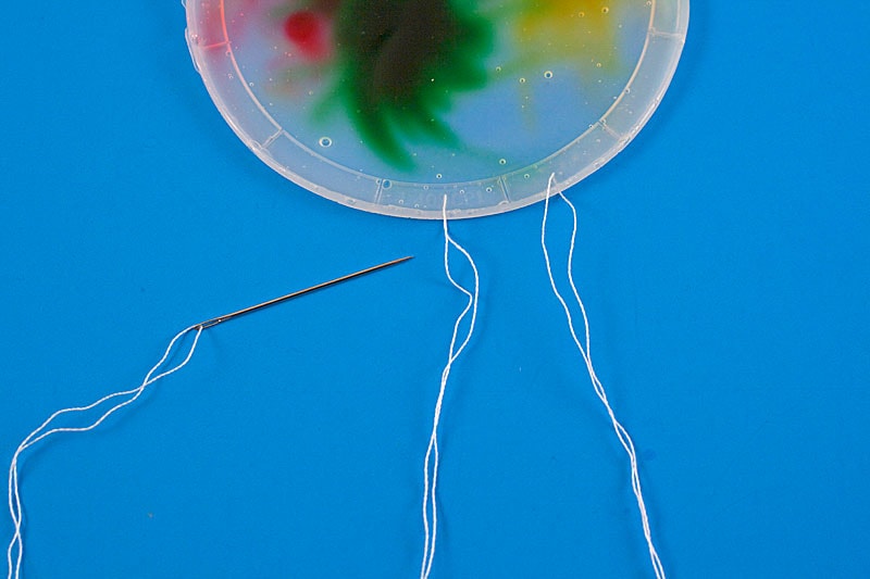threading needle through plastic lid