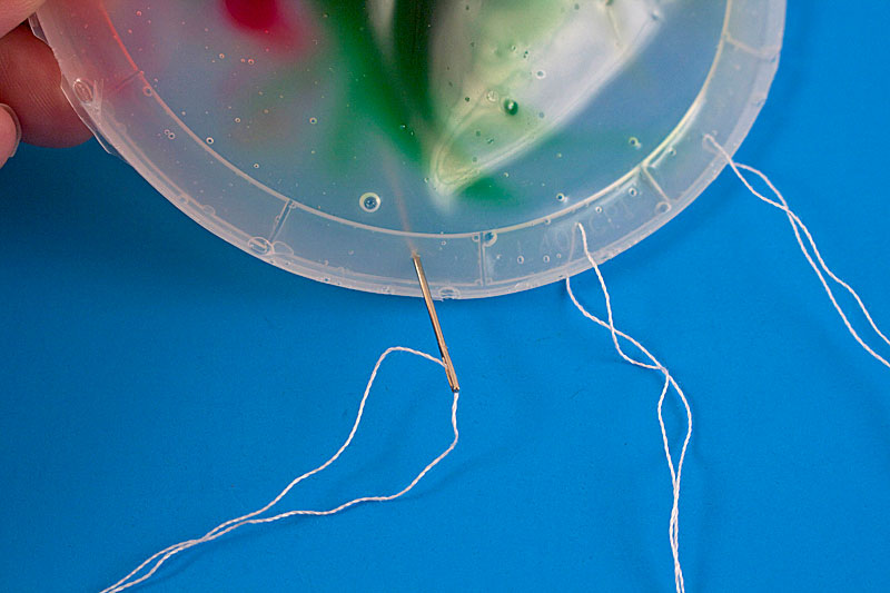 inserting needle into plastic lid