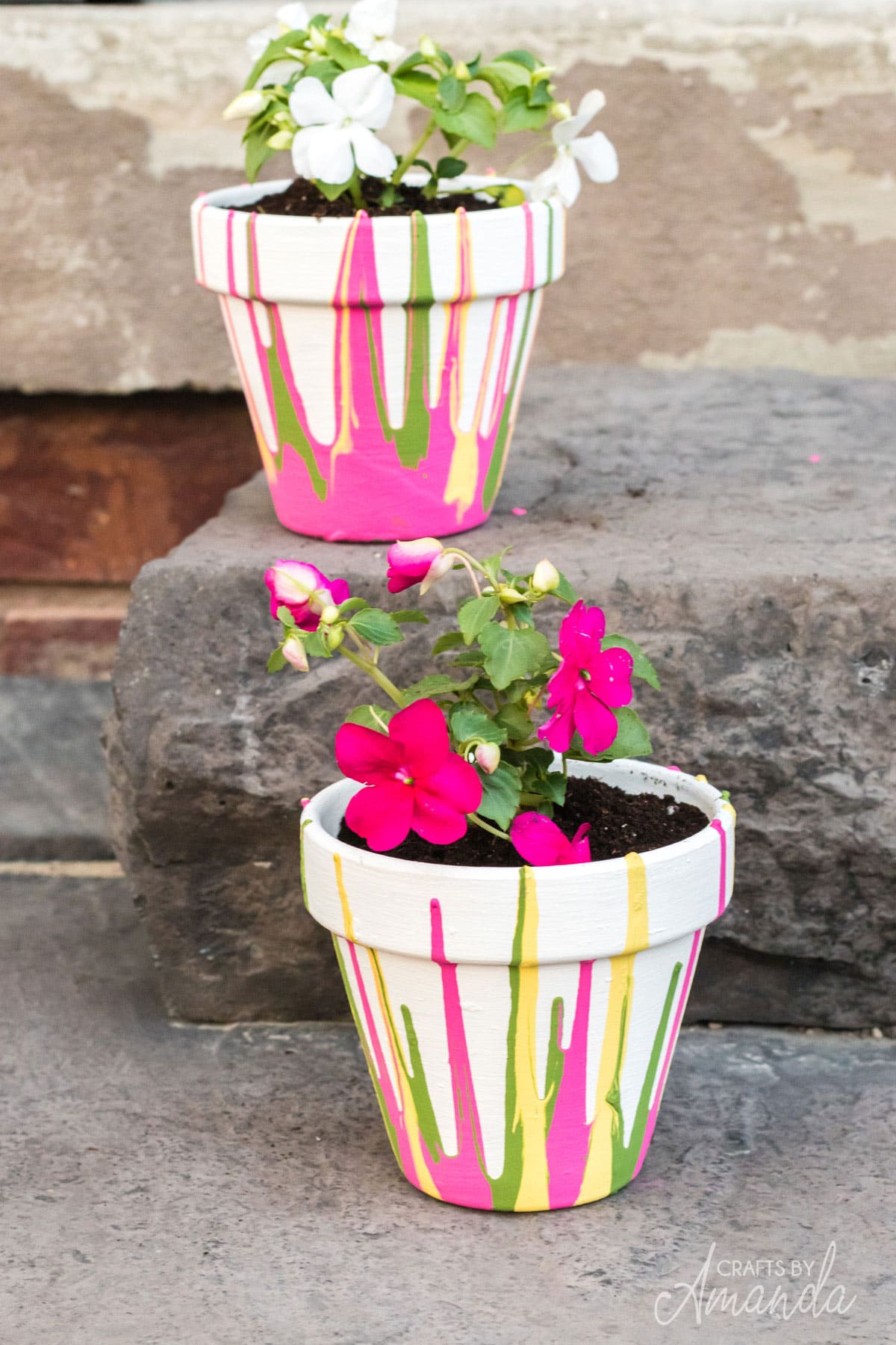 two drip painted pots with flowers on stairs