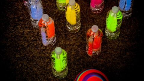water bottles with glow sticks set up like bowling pins