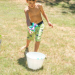 boy tossing sponge bomb into bucket