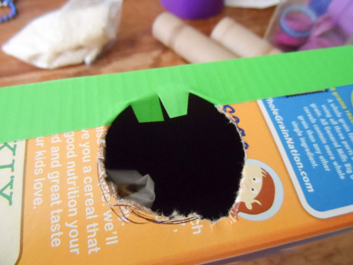 hole in cereal box with duck tape on it