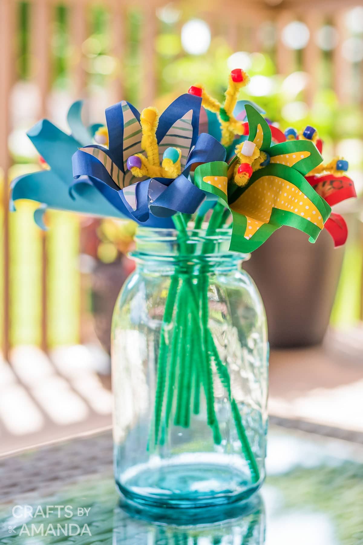 blue mason jar vase holding tropical paper flowers