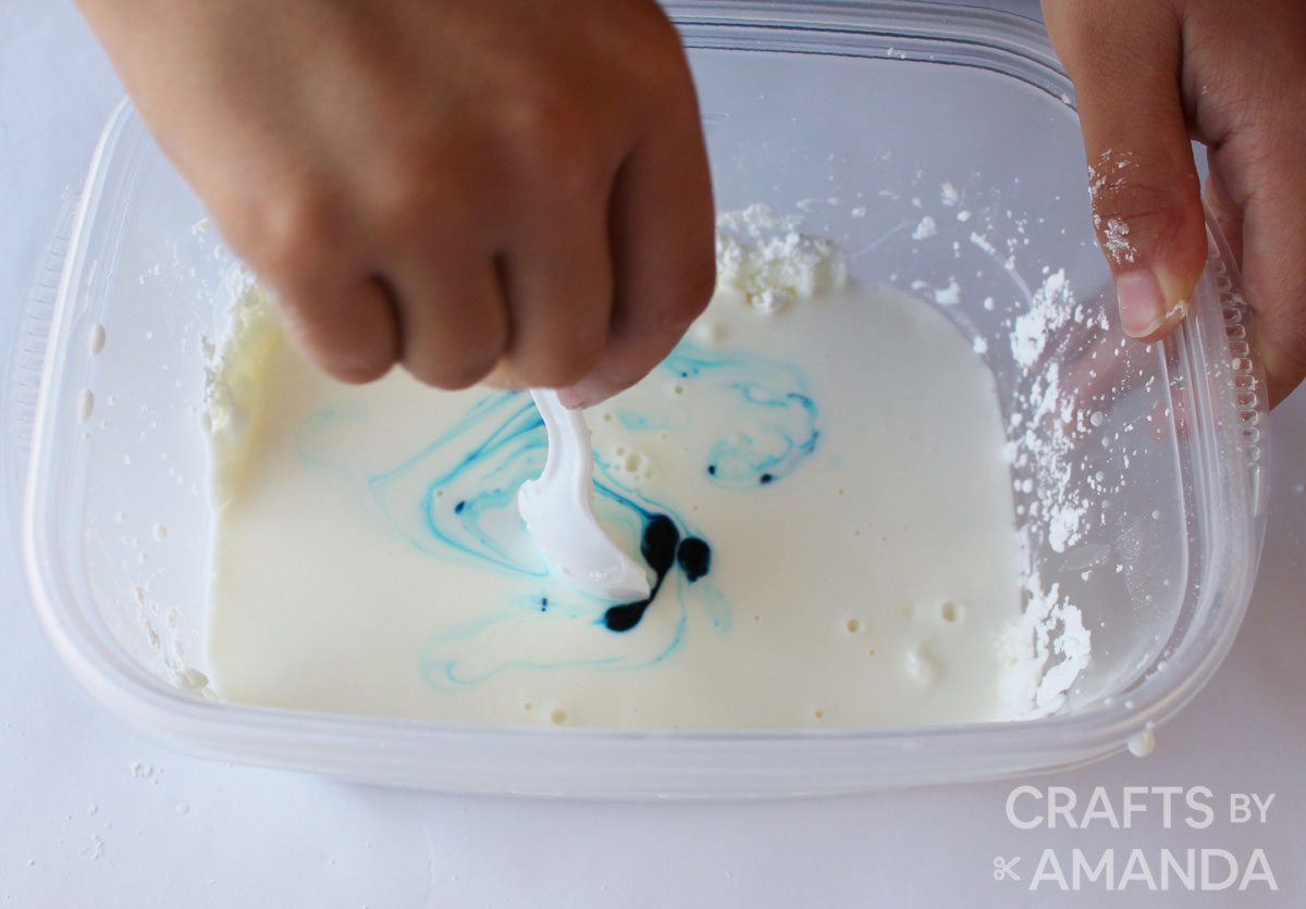 stirring ooblek solution and adding food coloring