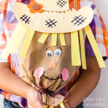 boy holding paper bag scarecrow